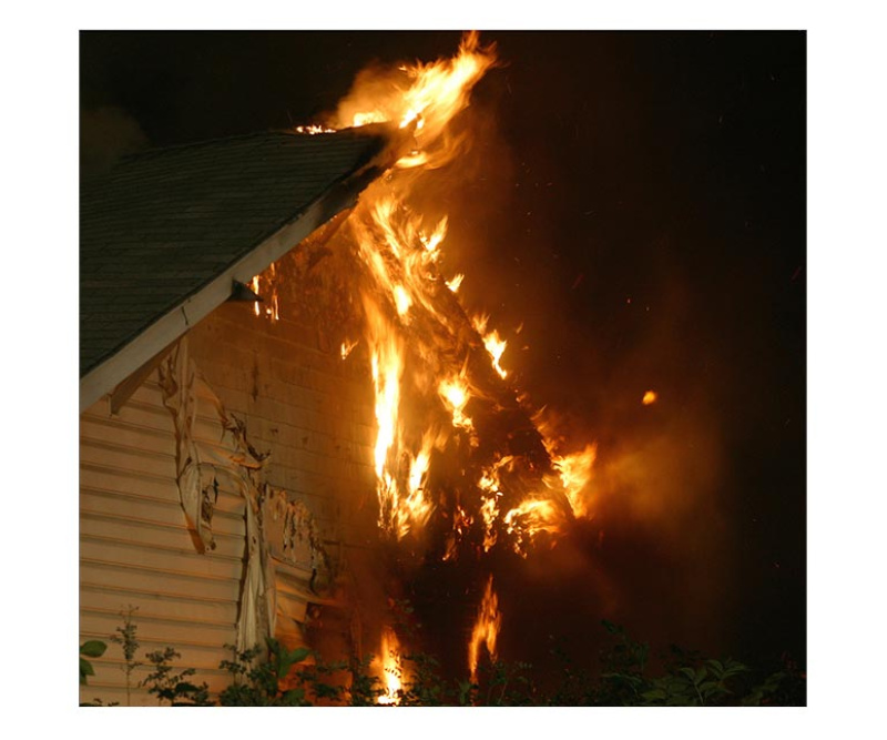 Two technicians in protective suits cleaning a fire-damaged kitchen